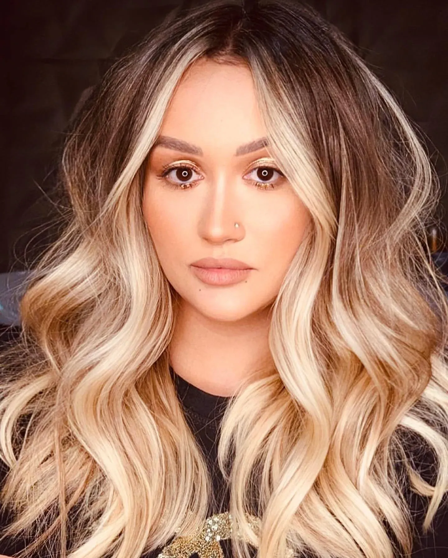 Long blonde balayage with a soft root shadow and loose waves