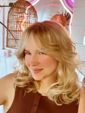 After: soft blonde layers with a curtain fringe, styled with volume