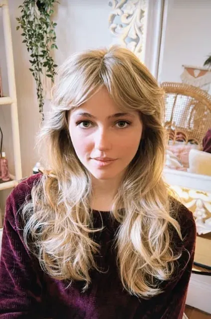 Long blonde shag with face-framing layers and a centre-parted fringe