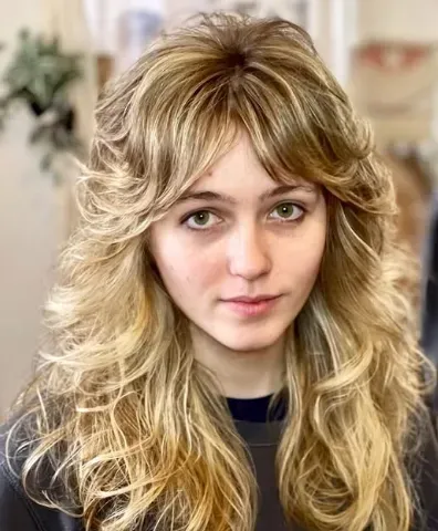 Blonde shag with a full, piecey fringe and choppy layers through the lengths