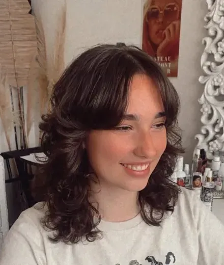 Dark, naturally curly shag with a curtain fringe and rounded volume
