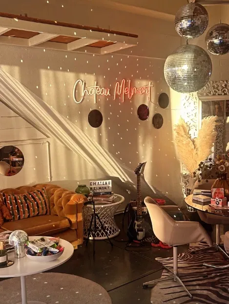 The studio lounge with a brown leather sofa, disco balls and a warm neon sign