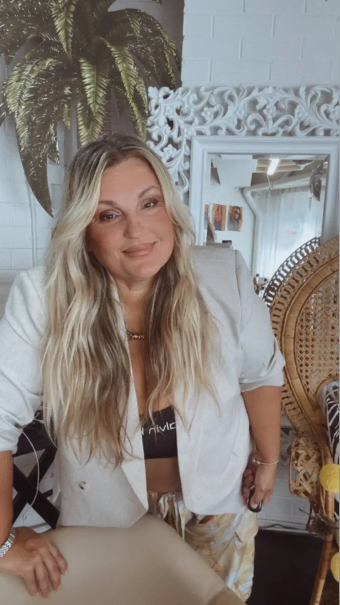 Milena, master hair artist, with long blonde waves, in her Glenelg North studio