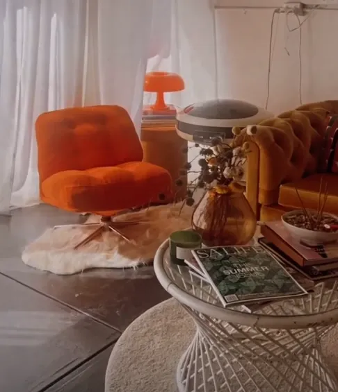 A 70s orange armchair and rattan side table in the studio lounge corner